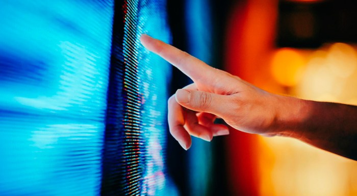 A closeup of a hand pointing at a screen